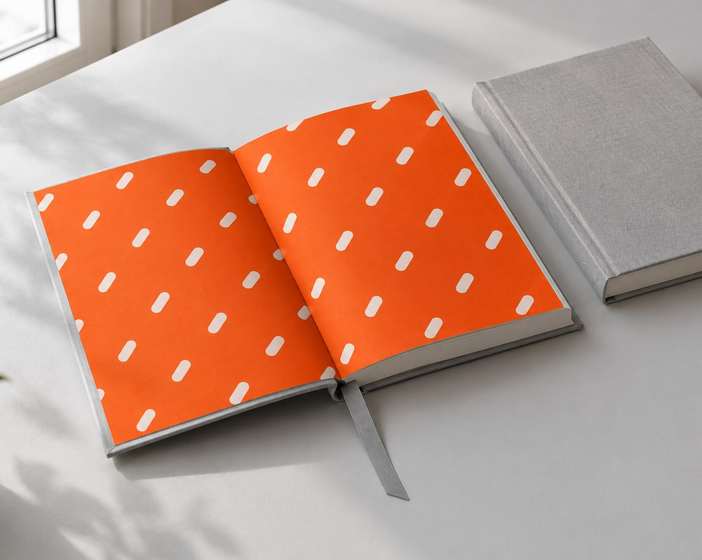 An open Fable book with orange endpapers printed with small white marks