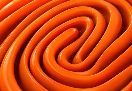 Glossy orange tubes coiled into a fingerprint pattern