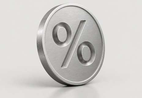 A brushed steel coin with a percent sign on a light grey background